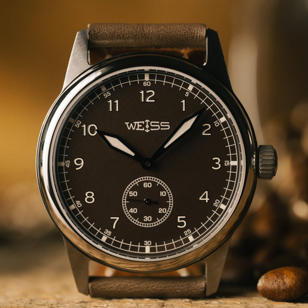 Weiss watch with brown leather strap on a wooden surface